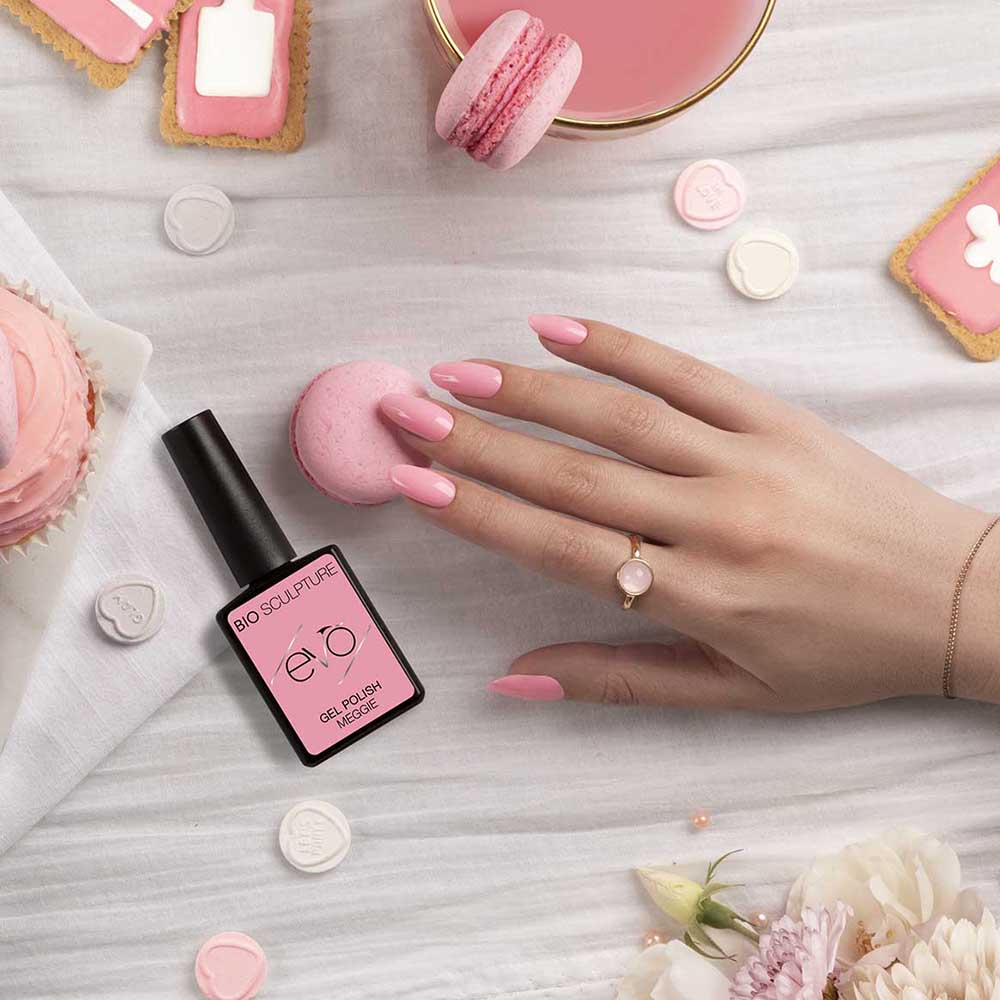 Painted pink nails on hands showing with a bottle of pink bio sculpture next to them